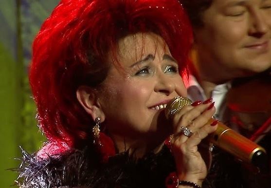 Bernadeta Kowalska na scenie, śpiewająca z pasją w otoczeniu zespołu 