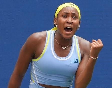 Coco Gauff świętująca zwycięstwo na korcie tenisowym, z uniesionymi rękami i uśmiechem, w tle rozentuzjazmowany tłum.