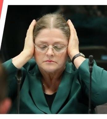 Krystyna Pawłowicz podczas publicznego wystąpienia, z ekspresyjnym wyrazem twarzy, odzwierciedlającym jej stanowczość i pasję.