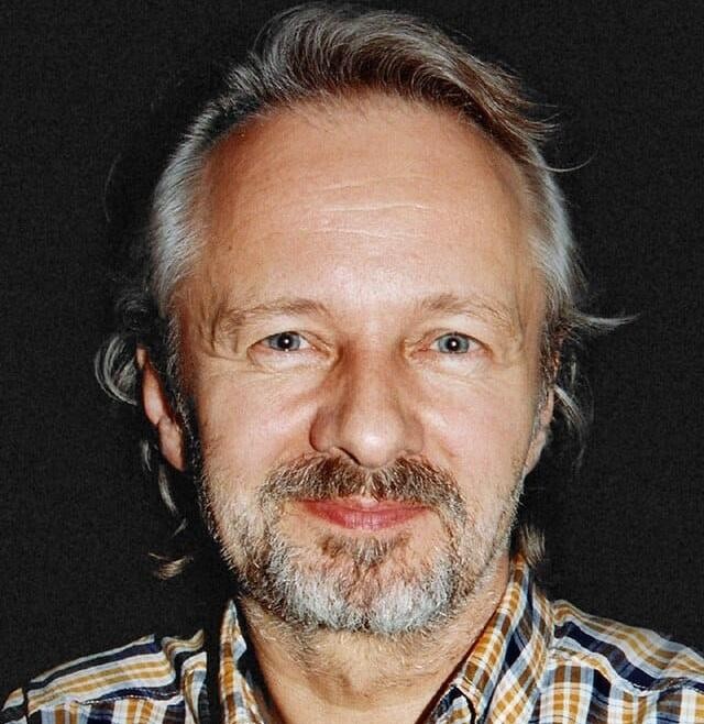 Krzysztof Stroiński w jednej ze swoich ikonicznych ról, uchwycony w dynamicznym ujęciu, oddającym intensywność i głębię jego aktorskiej kreacji.