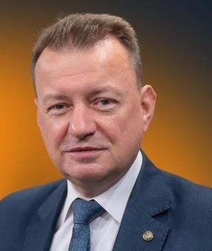 Mariusz Błaszczak jako minister obrony narodowej, w kontekście działań związanych z polskim wojskiem lub podczas oficjalnego wystąpienia, podkreślający jego rolę w obszarze bezpieczeństwa.