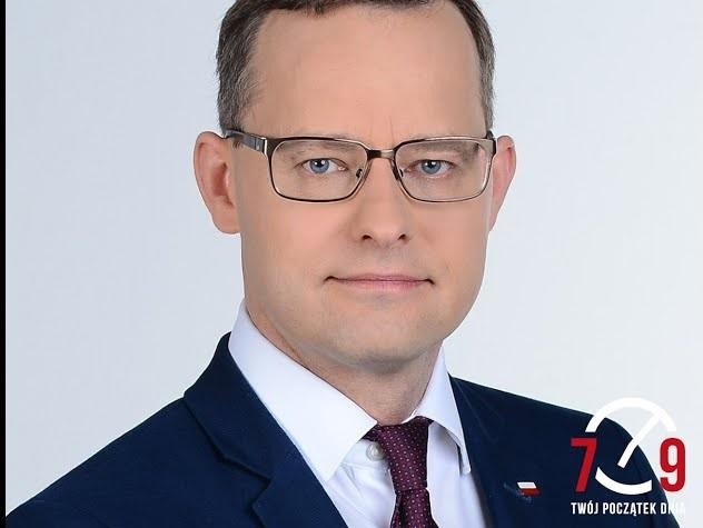 Marcin Romanowski podczas debaty w Sejmie, z innymi posłami w tle, symbolizujący intensywność życia politycznego.