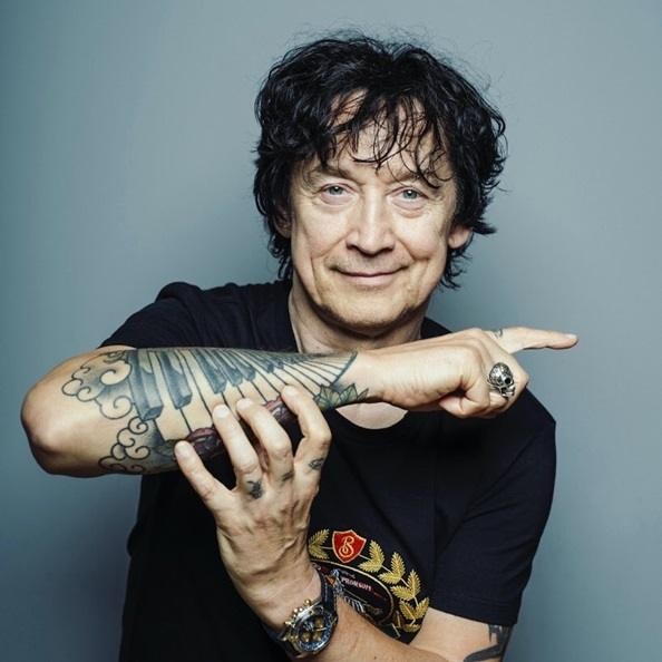 Jan Borysewicz z Lady Pank grający na gitarze elektrycznej podczas koncertu, z widoczną pasją i skupieniem.