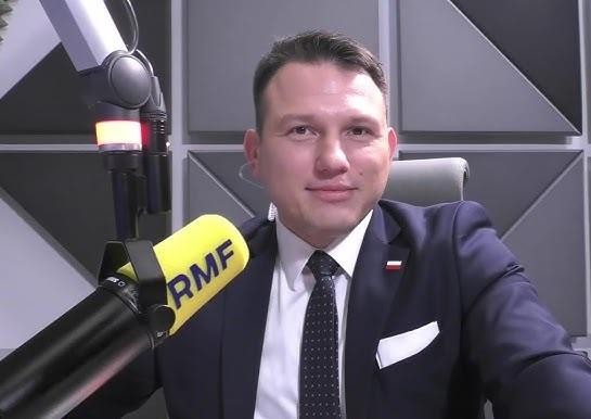 Alt: Sławomir Mentzen podczas wiecu politycznego, dynamicznie przemawiający do publiczności, z widocznym zaangażowaniem i charyzmą.