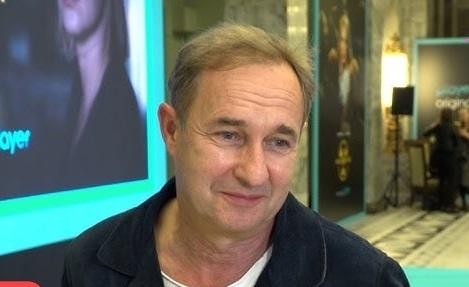 Marek Kalita na scenie teatralnej, w trakcie występu lub reżyserowania, ukazujący jego pasję i zaangażowanie w sztukę.