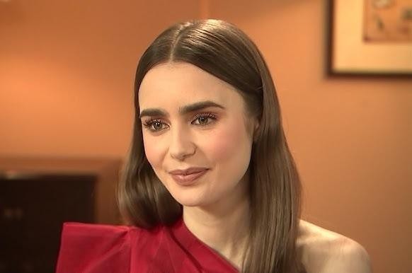 Młoda Lily Collins w roli dziennikarki, z mikrofonem lub notatnikiem, podczas relacjonowania wydarzenia.
