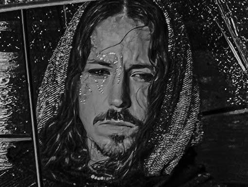 Michał Szpak śpiewający z mikrofonem na scenie, z ekspresyjną mimiką i rozwianymi włosami, oświetlony dynamicznym światłem.