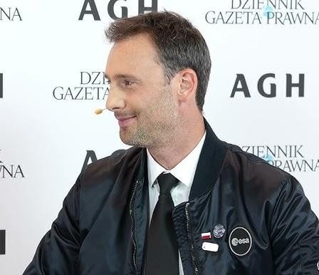 Alt: Sławosz Uznański w swobodnej stylizacji, uśmiechnięty, w otoczeniu sugerującym jego rodzinne miasto Łódź, ukazujący prywatną stronę astronauty.