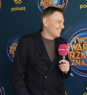 Krzysztof Ibisz z rodziną – Joanną Kudzbalską i dziećmi, w ciepłym, rodzinnym ujęciu, symbolizującym jego życie prywatne.